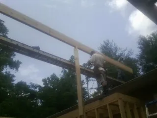 Carpenter setting a ridge beam over a new addition frame — Ice Dam Removal by Roofing Brothers in Lehi