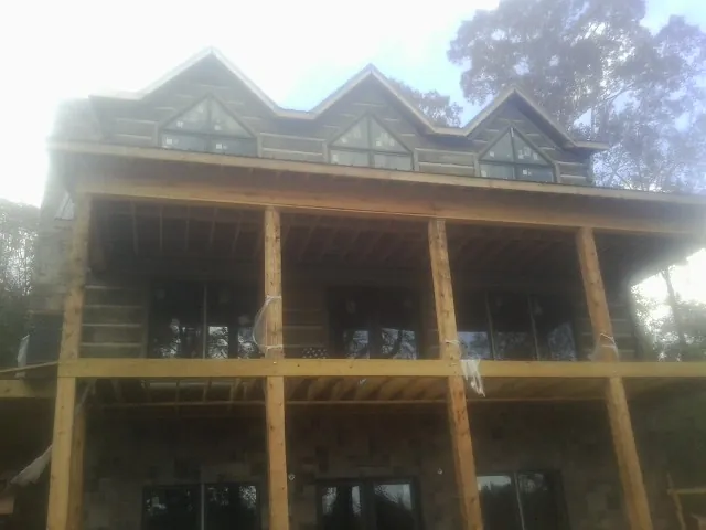Dormers and porch framing on a large log home under construction — Roof Coating work by our crew in Lehi