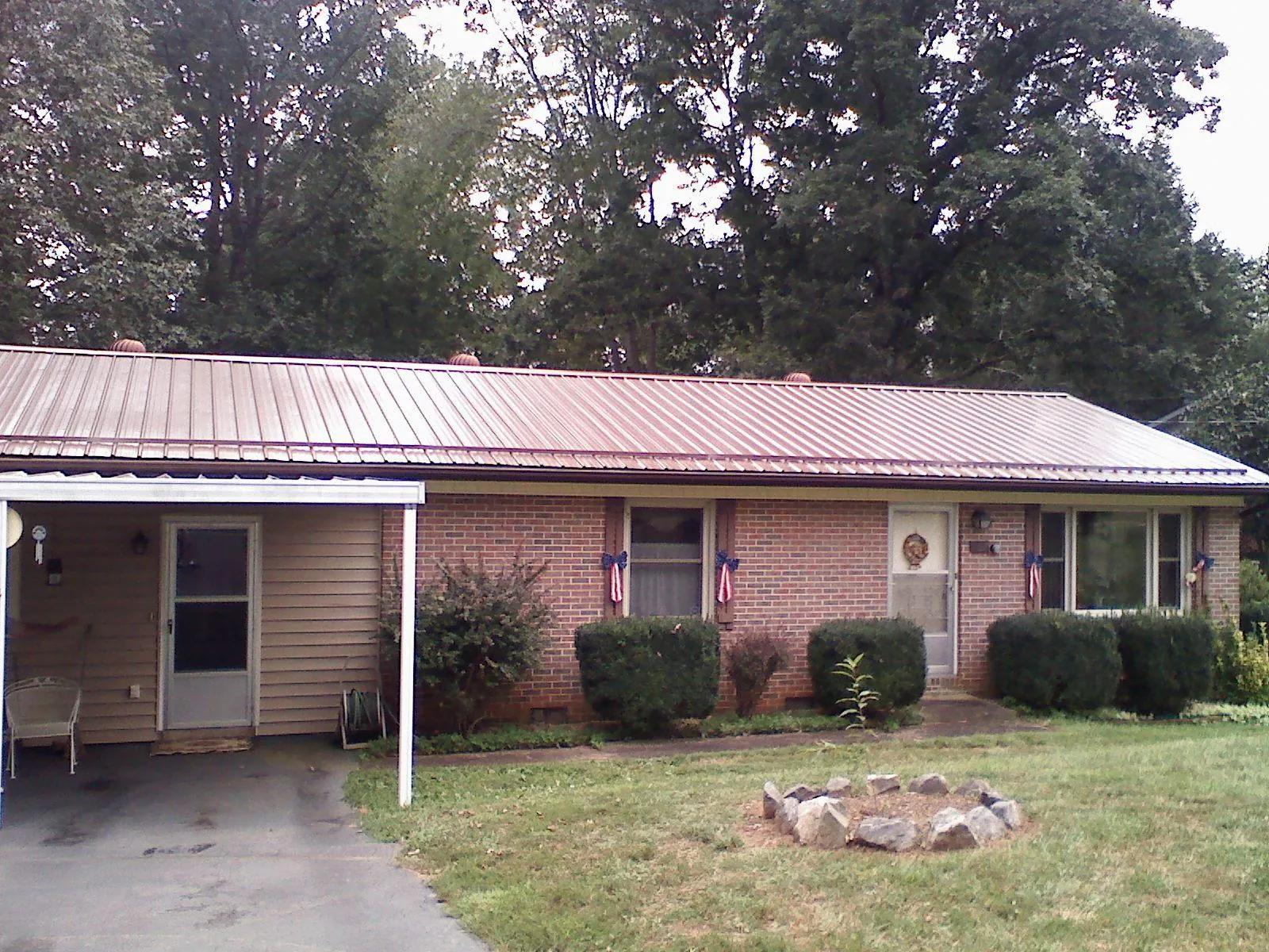 Bronze metal roof and carport on a brick ranch home — Roof Repair work by our crew in Lehi